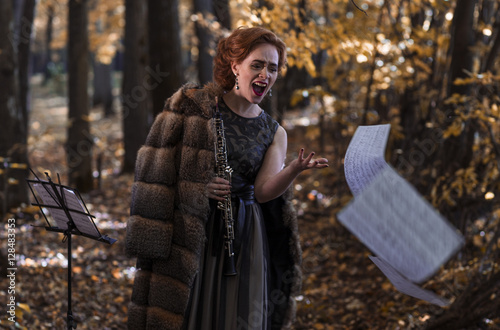 Emotional woman throwing the musical sheets and holding an oboe in hand