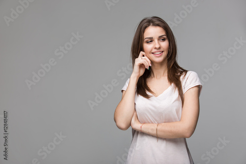 Portrait of beautiful brunette woman with natural make-up, on grey background