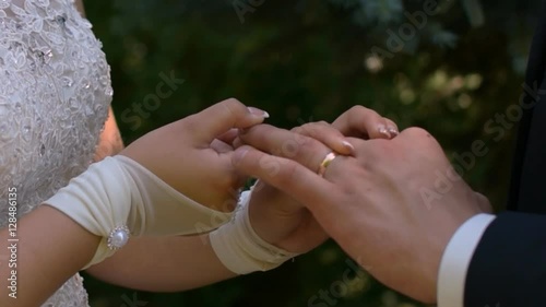 Happy bride persistently wears the ring on the groom