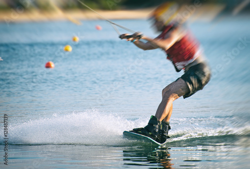 Man on wakeskate doing tricks. Cable Wakeboard. photo