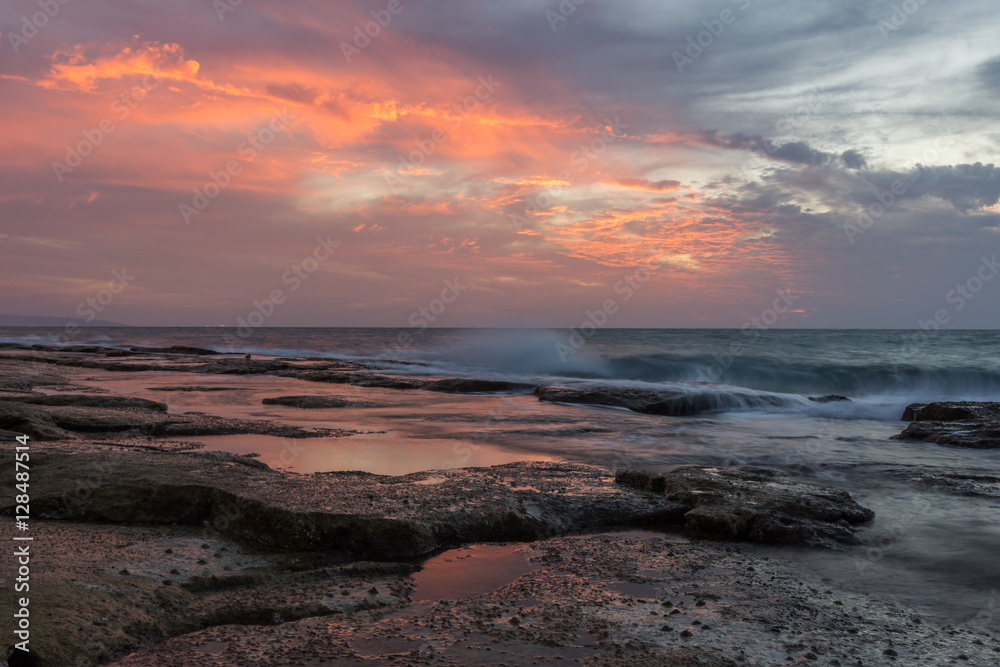  Vivid orange and soft blue colors after sunset over the rocky coastline of western Galilee