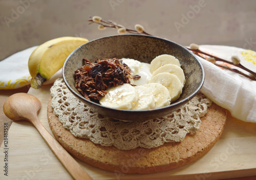 Yogurt with cocoa granola, banana and honey on top