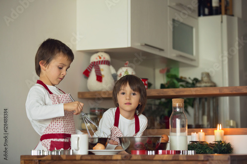 Two sweet children, boy brothers, preparing gingerbread cookies