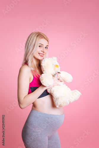 Young pretty pregnancy having white toy bear