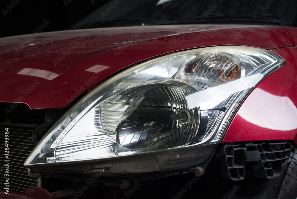Auto body repair series : Closeup of red car headlights waiting for repaint
