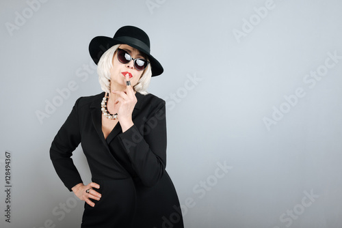 Charming senior woman touching her lips by  finger