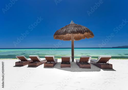 Sun umbrella and beach beds on  seashore photo