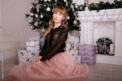 Young beautiful woman in  elegant evening dress sitting on floor © ribalka yuli