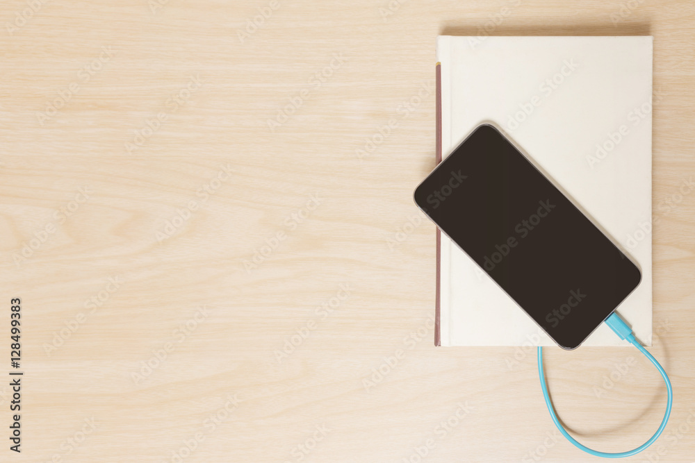 Smart phone connected to the old book with a cable Smart phone connected to the old book with a cable