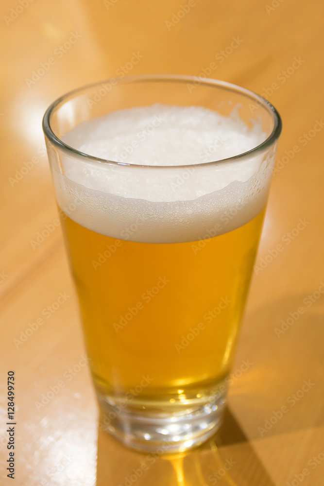 A glass of beer on the wood table A glass of beer on the wood table