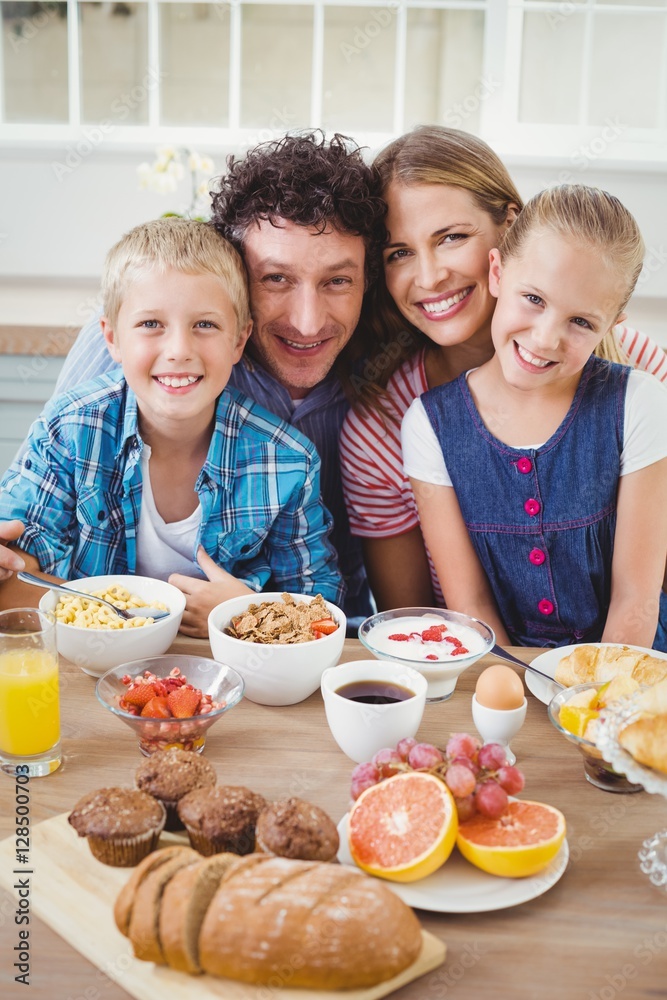 Portrait of family smiling while having breakfast