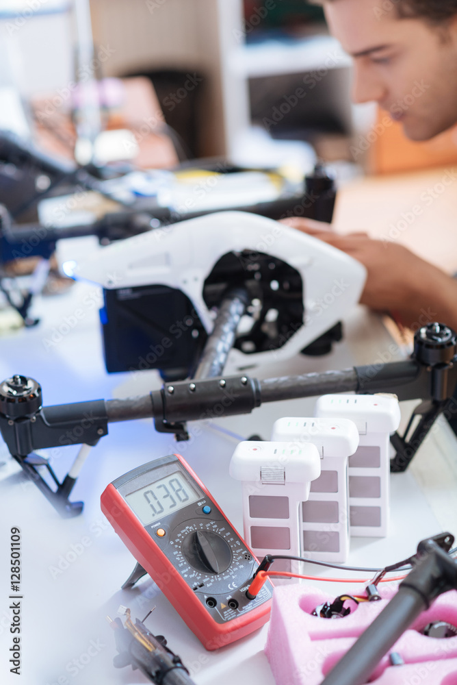 Close up of ambitious mans hands putting together drone mechanism Close up of ambitious mans hands putting together drone mechanism