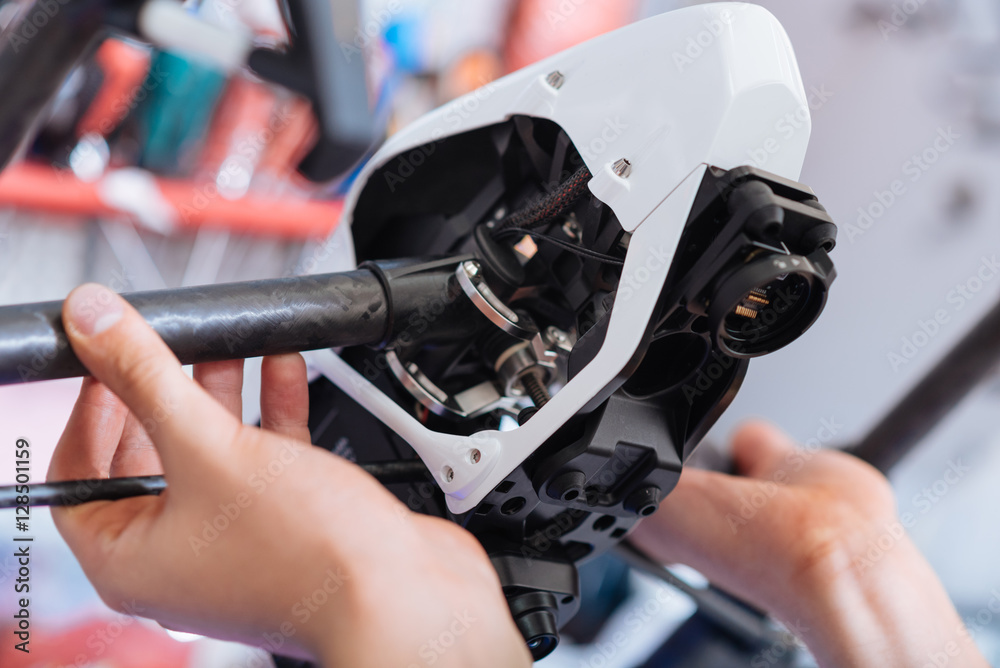 Fototapeta premium Close up of mans hands putting drone parts together