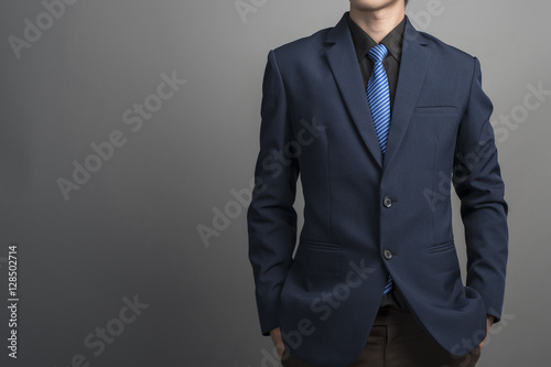 Close up of businessman in blue suit confident on gray backgroun