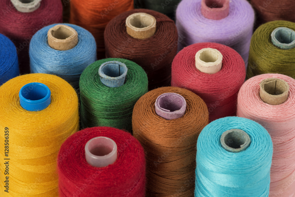 Still life of colorful spools of thread on a white background - Closeup Detail Still life of colorful spools of thread on a white background - Closeup Detail