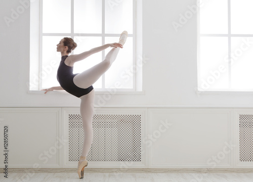 Beautiful ballerine stands in arabesque ballet position