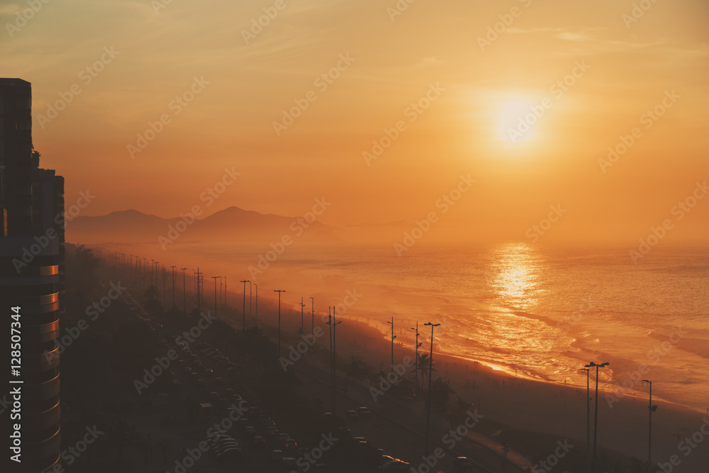 Top view of the ocean, beach, coastline, road and far hills, dramatic and colorful evening, Rio de Janeiro, Brazil