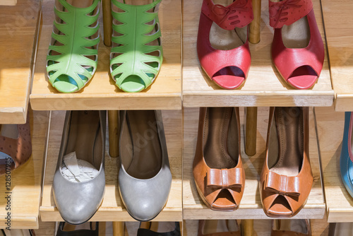 Lady's different shoes in row. Woman's footwear on boutique floor. 
 photo