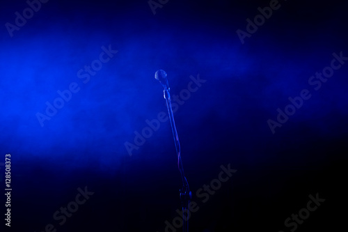 Vocal microphone on stage. Singing microphone on stand in blue lights at concert
