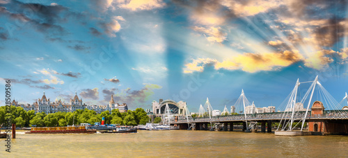 Photo Hungerford Bridge at sunset with city skyline along Thames, Lond