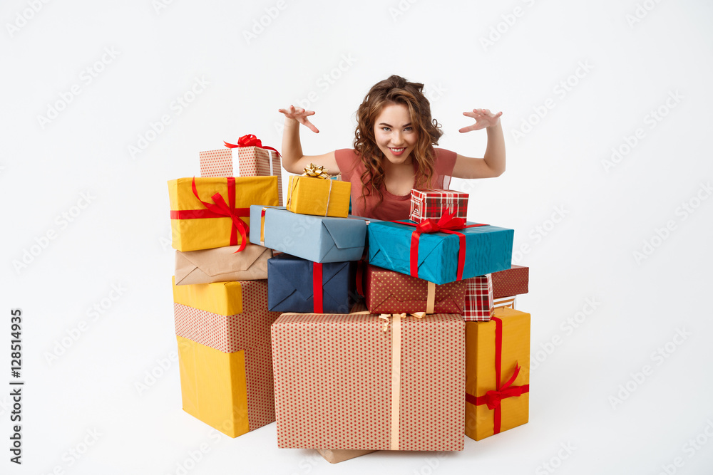 Young beautiful curly girl among gift boxes Isolated Young beautiful curly girl among gift boxes Isolated