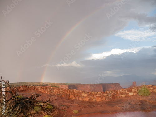 Rainbow mixed with sun over Dead Horse Point in Canyonlands National Park Utah