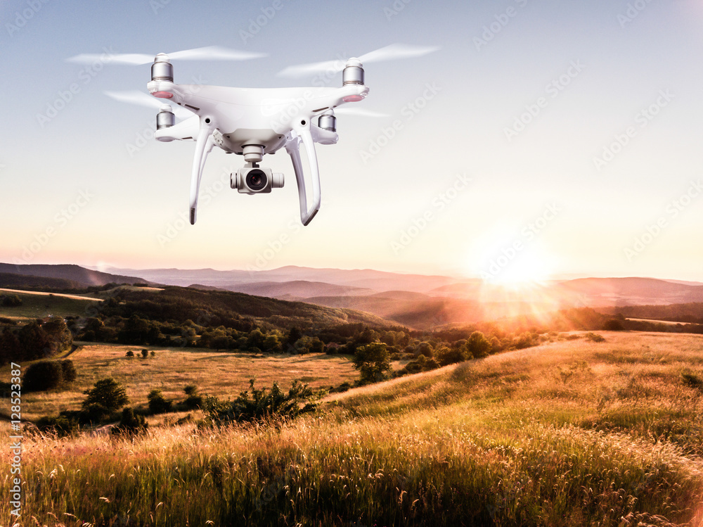 Hovering drone taking pictures of green nature at sunset Hovering drone taking pictures of green nature at sunset
