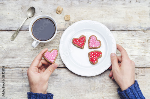 Male hands holding cookie in the forms of heart