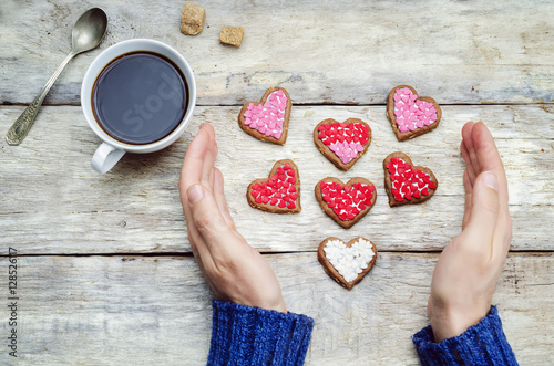 Male hands holding cookie in the forms of heart