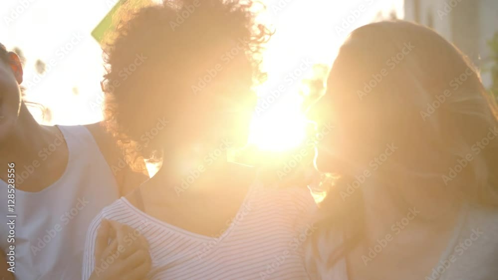 Three adult female friends in the street, head and shoulders