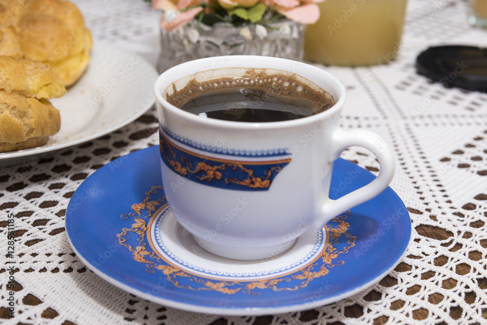 Coffee in the cup with cream puffs on a plate Coffee in the cup with cream puffs on a plate