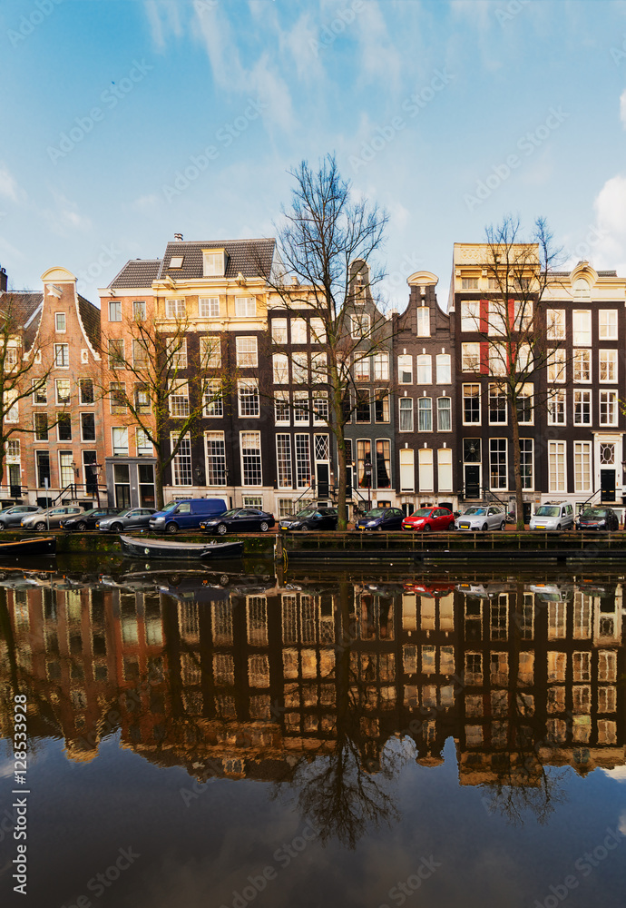 Facades of old dutch houses over canal with mirror reflections, Amstardam, Netherlands