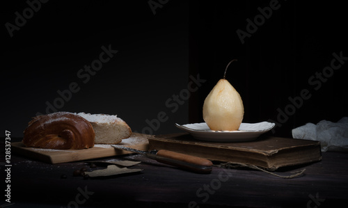 still life. pears, weet roll, old books on a dark background. painting, vintage.