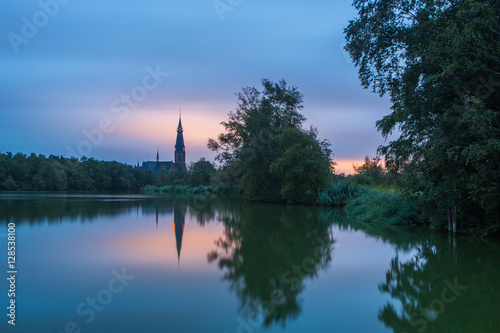 Church 'Urbanuskerk' viewed from the lakeside just before sunrise (amstelveen, Netherlands) photo