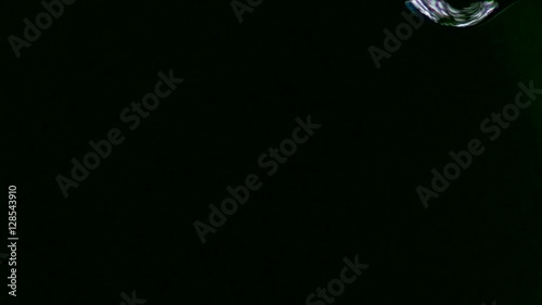 Single drop fall in a black background in slow motion