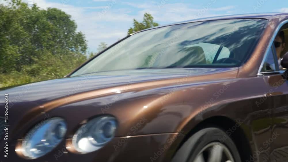 Expensive auto moving on roadway, driver enjoying car trip in resort town