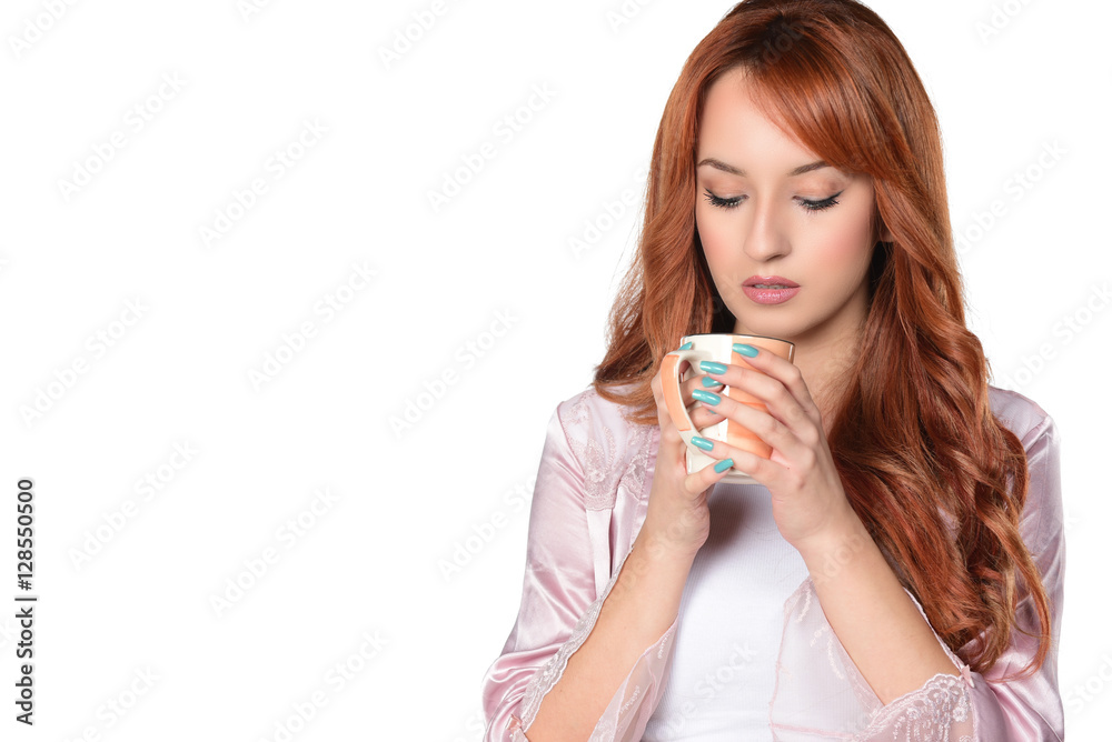 Portrait of lovely redheaded woman siting on big pillow holding drinking cup of coffee, tea, on white background Portrait of lovely redheaded woman siting on big pillow holding drinking cup of coffee, tea, on white background