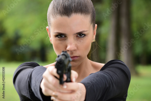 Mad woman pointing a gun at someone