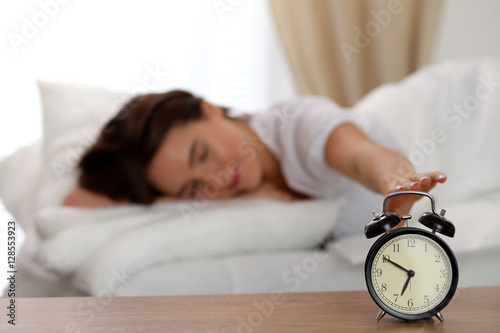 Wallpaper Mural Sleepy young woman stretching hand to ringing alarm willing turn it off. Early wake up, not getting enough sleep, getting work concept. Torontodigital.ca