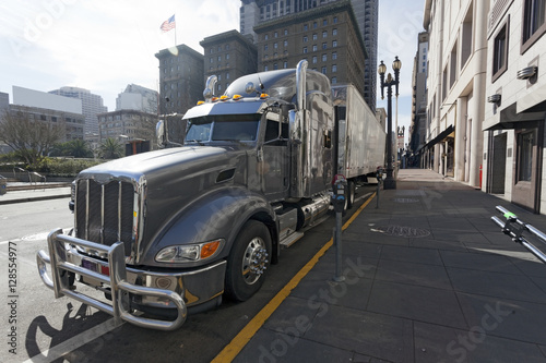 Foto Side view of gray semi cab and trailer parked on urban street