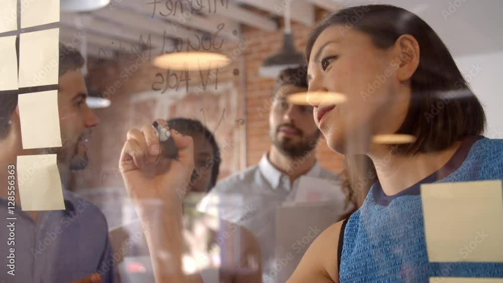 Businesswoman Writing Ideas On Glass Screen During Meeting Businesswoman Writing Ideas On Glass Screen During Meeting
