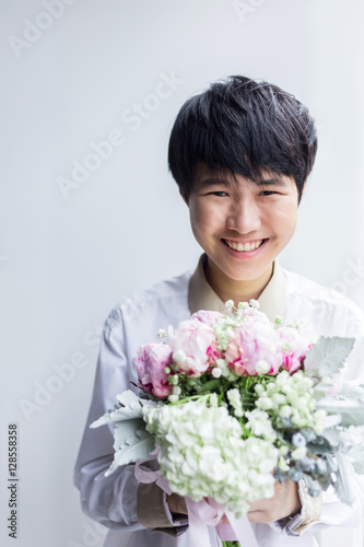 Happy toddler asian cute girl holding a bouquet of wildflowers w