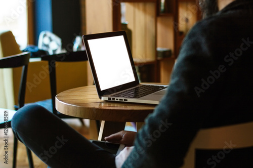 Young man looking at his laptop, close up