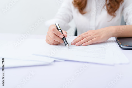 Business woman filling information on document.