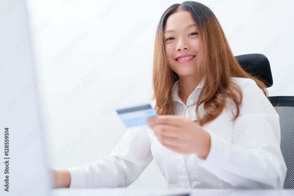 Young woman using credit card paying on laptop. Young woman using credit card paying on laptop.