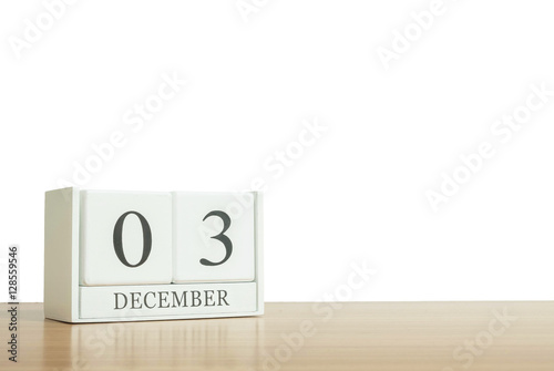 Closeup surface white wooden calendar with black 3 december word on blurred brown wood desk isolated on white background with copy space , selective focus at the calendar