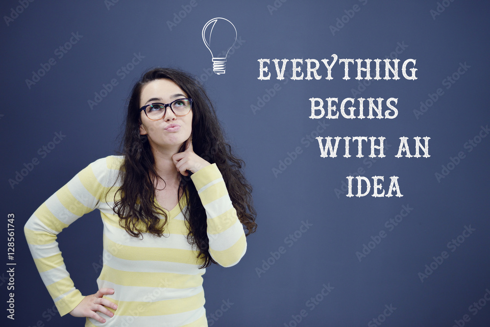 Young thinkful woman on blue gray background with idea sign