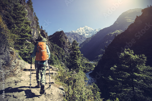 young woman backpacker trekking on himalaya mountain trail