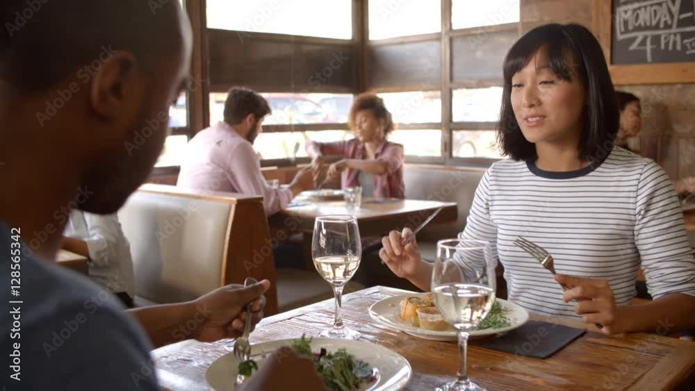 Over shoulder view of couple having lunch in a restaurant Over shoulder view of couple having lunch in a restaurant