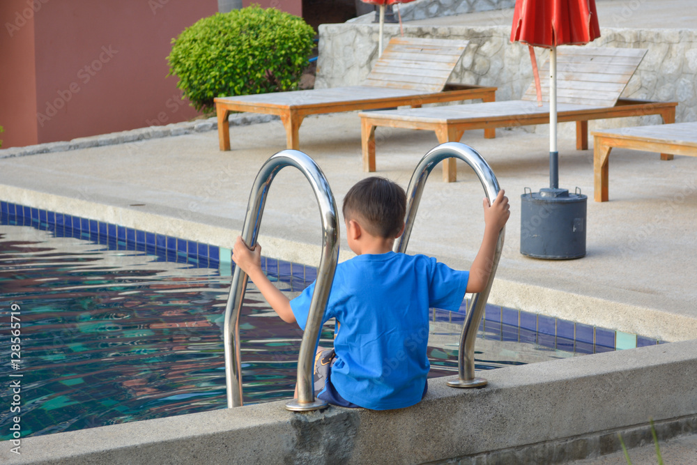 Naklejka premium A boy site on stairs pool